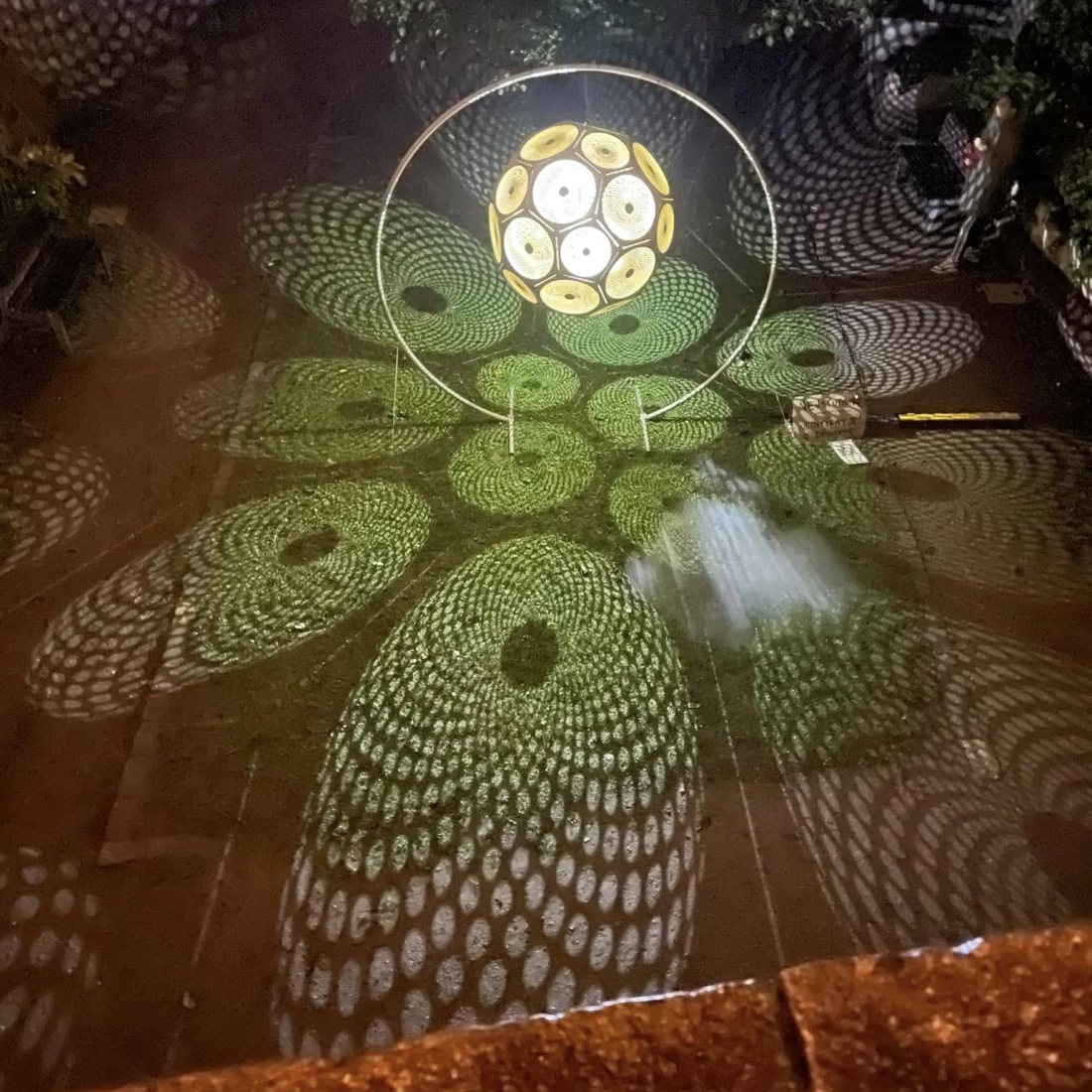 Světelný geometrický objekt mezi stromy na festivalu Světlo v ulicích